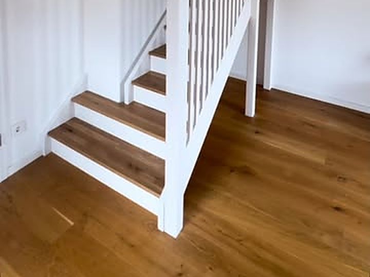 Weiße Treppe mit Eichenstufen und Lattengeländer zu einer Hochebene